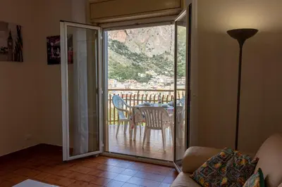 a living room with a sliding glass door leading to a table at casavacanzabordonaro in Palermo