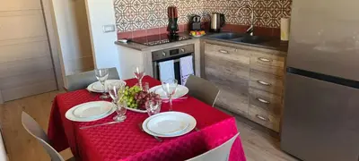 a table with a red table cloth and wine glasses at Ruby Home in Palermo