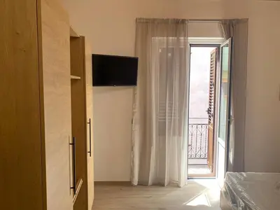 a bedroom with a door to a window with a balcony at Ruby Home in Palermo