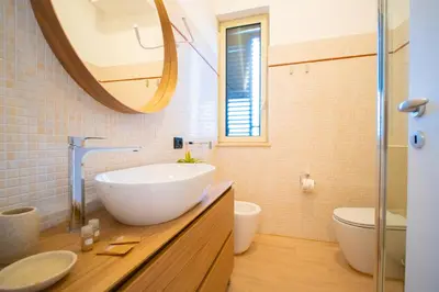 a bathroom with a white bowl sink and a mirror at Solemar Sicilia - Vista Mare Alla Cala in Palermo