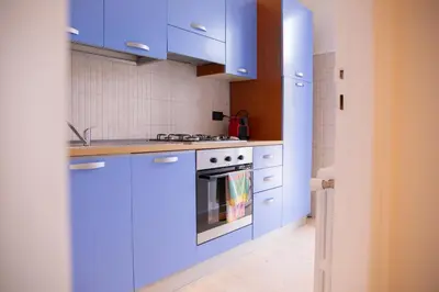 a kitchen with blue cabinets and a stove at Solemar Sicilia - Vista Mare Alla Cala in Palermo