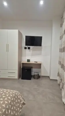 a bedroom with a bed and a desk with a television at Casa Leo in Palermo