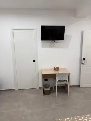 a room with a table and a television on a wall at Casa Leo in Palermo