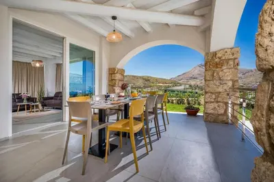 a dining room with a table and chairs with a view at Villa Coraline - Castellammare in Balata di Baida