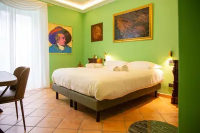 a bedroom with a large bed with green walls at Solemar Sicilia - Goethehaus in Palermo