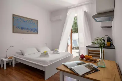 a white room with a bed and a table and a window at Sunny studio with terrace in best central area in Palermo