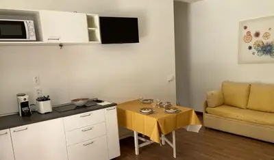 a small kitchen with a table and a couch at Sunny studio with terrace in best central area in Palermo
