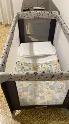 a crib with a mattress on top of it at Sunny studio with terrace in best central area in Palermo
