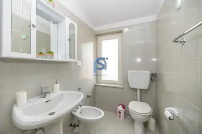 a white bathroom with a sink and a toilet at Villa Oltremare in Lascari