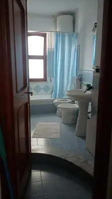 a bathroom with two toilets and a sink and a shower at Rocca Appartament Palermo Beach in Palermo