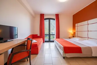 a bedroom with a red bed and a red couch at Al ritrovo in Castelluzzo