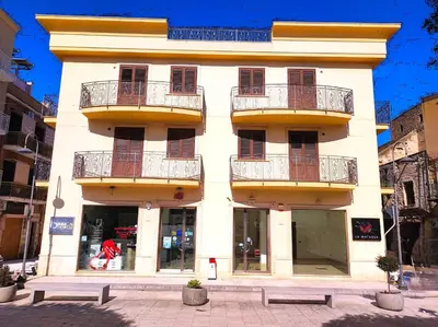 a white building with balconies on the side of it at Casa La Plaza in Balestrate