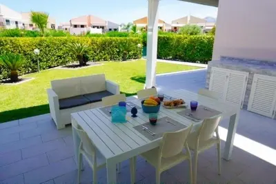 a white table and chairs on a patio at Casa Roccella in Buonfornello