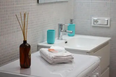 a bathroom with a sink and a vase with towels at L'arco Sul Mare in Balestrate