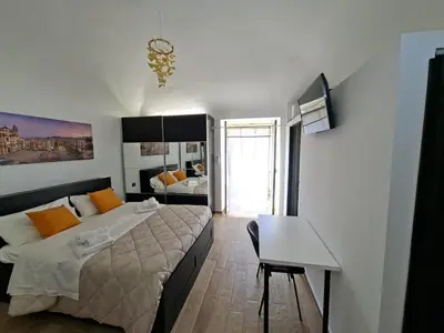 a bedroom with a bed and a desk in it at Central Post Office Guest House in Palermo
