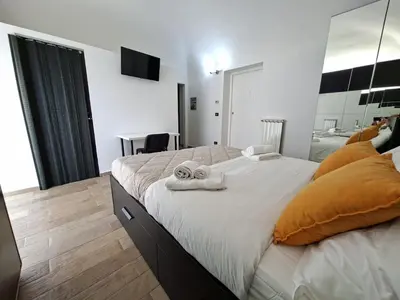 a bedroom with a large bed with towels on it at Central Post Office Guest House in Palermo