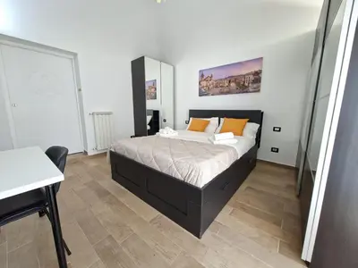a bedroom with a bed and a desk in it at Central Post Office Guest House in Palermo