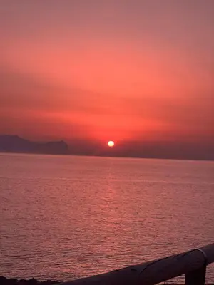 a sunset over the water with the sun in the sky at Casa Lo Bianco in Terrasini