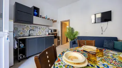 a kitchen and dining room with a table with plates on it at Living Ballarò by Rentbeat in Palermo