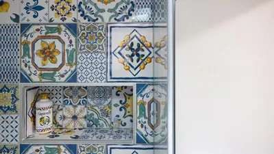 a bathroom with blue and white tiles on a wall at Living Ballarò by Rentbeat in Palermo