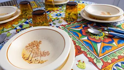 a table with plates and bowls on a colorful table cloth at Living Ballarò by Rentbeat in Palermo