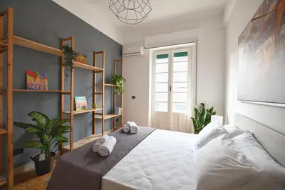 a bedroom with a white bed with towels on it at La Lumia Apartment in Palermo