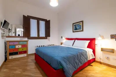 a bedroom with a red bed and a dresser at GuestHost - Al Cassaro Holiday Home in Palermo