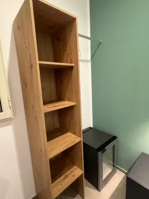a wooden book shelf in a room with a desk at Luxury Rooms Soraja in Palermo