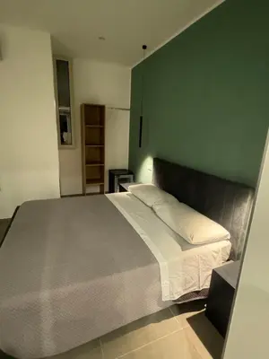 a bedroom with a bed and a green wall at Luxury Rooms Soraja in Palermo