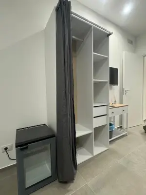 a white closet with a black curtain in a room at Luxury Rooms Soraja in Palermo