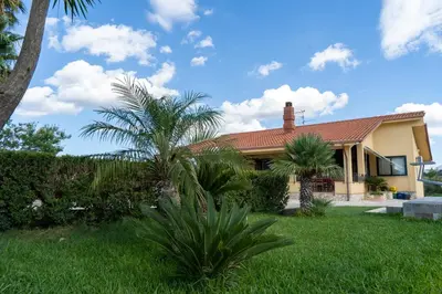 a house with palm trees in the yard at Villa Oasi della Pace based in Partinico in Partinico
