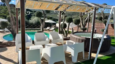 a pergola with white chairs and a pool at Al Grande Pino - Private pool, Jacuzzi and amazing Sunset in Campofelice di Roccella