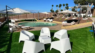 a group of white chairs sitting next to a pool at Al Grande Pino - Private pool, Jacuzzi and amazing Sunset in Campofelice di Roccella