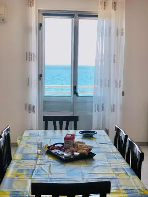 a dining room table with a view of the ocean at Attico Giusy in Balestrate