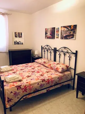 a bedroom with a bed with a floral bedspread at Attico Giusy in Balestrate