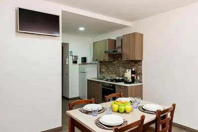 a kitchen and dining room with a table and chairs at Meschita Little House in Palermo