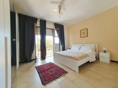 a bedroom with a white bed and a large window at Apartment Happy House by Interhome in Palermo