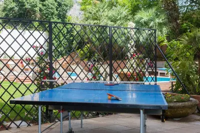 a blue ping pong table in front of a fence at Villa Castelforte, con piscina a Mondello in Palermo