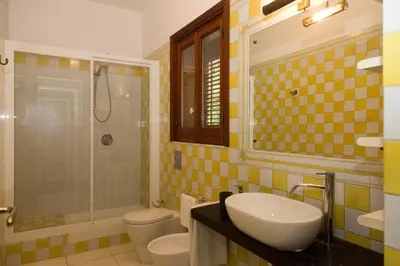 a bathroom with two toilets and a sink and a shower at Villa Castelforte, con piscina a Mondello in Palermo