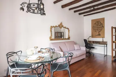 a living room with a table and a pink couch at Cala & Cassari View By DomuSicily in Palermo
