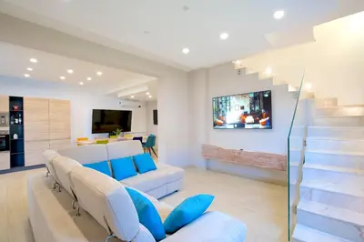 a living room with a white couch and a staircase at Private Villa, Sun & Pool in Mandra Capreria