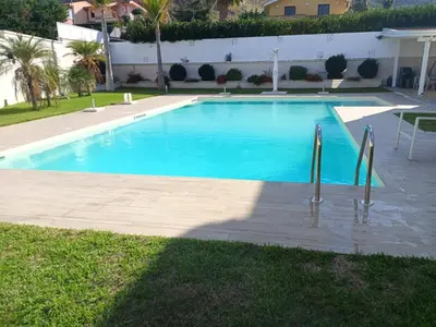 a large swimming pool with blue water in a yard at Private Villa, Sun & Pool in Mandra Capreria
