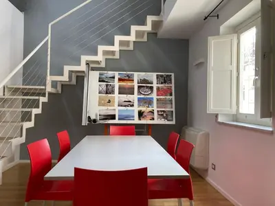a dining room with a white table and red chairs at Dai Pupi al 68 in Palermo