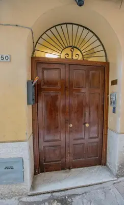 a large wooden door in a building with an arch at La Bucceria in Palermo