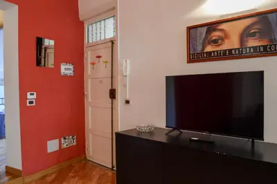 a living room with a flat screen tv on a dresser at Appartamento moderno tra Stazione, Via Maqueda e Ballarò in Palermo