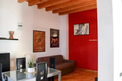 a living room with a red door and a couch at Appartamento moderno tra Stazione, Via Maqueda e Ballarò in Palermo