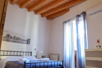 a bedroom with a bed and a large window at Appartamento moderno tra Stazione, Via Maqueda e Ballarò in Palermo