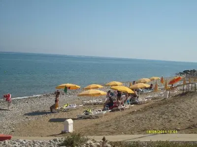a beach with yellow umbrellas and people on the beach at Sweet Summer House in Campofelice di Roccella