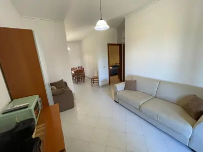 a living room with a couch and a tv at Sweet Summer House in Campofelice di Roccella