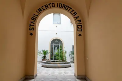 an archway leading to the entrance of a building with a fountain at GuestHost - Casa Giacomo in central Palermo in Palermo